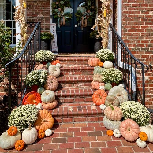 Custom fall porch design with pumpkins, gourds, and mums by Fall Porch Charm in the Triangle, NC
