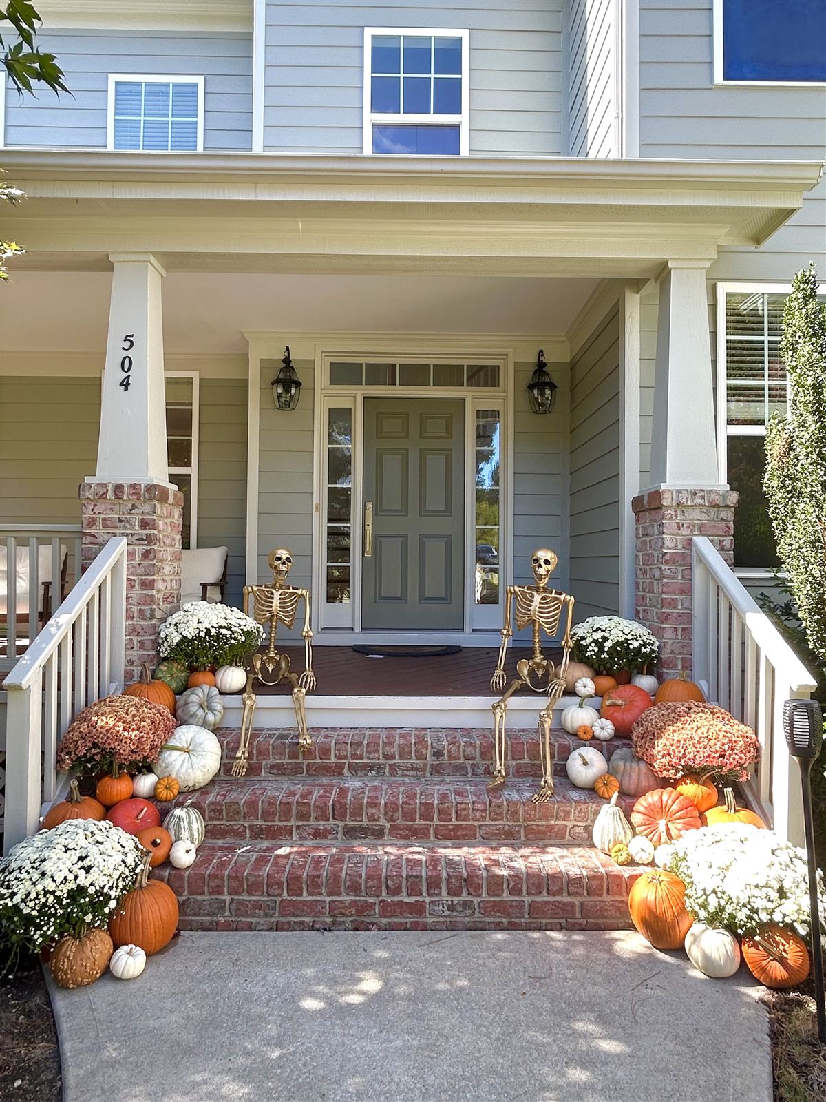 Fall front entrance decorated with pumpkins and fall flowers