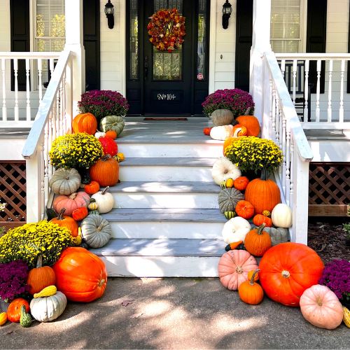 Grand Harvest Extravaganza fall porch display with grand pumpkins and mums